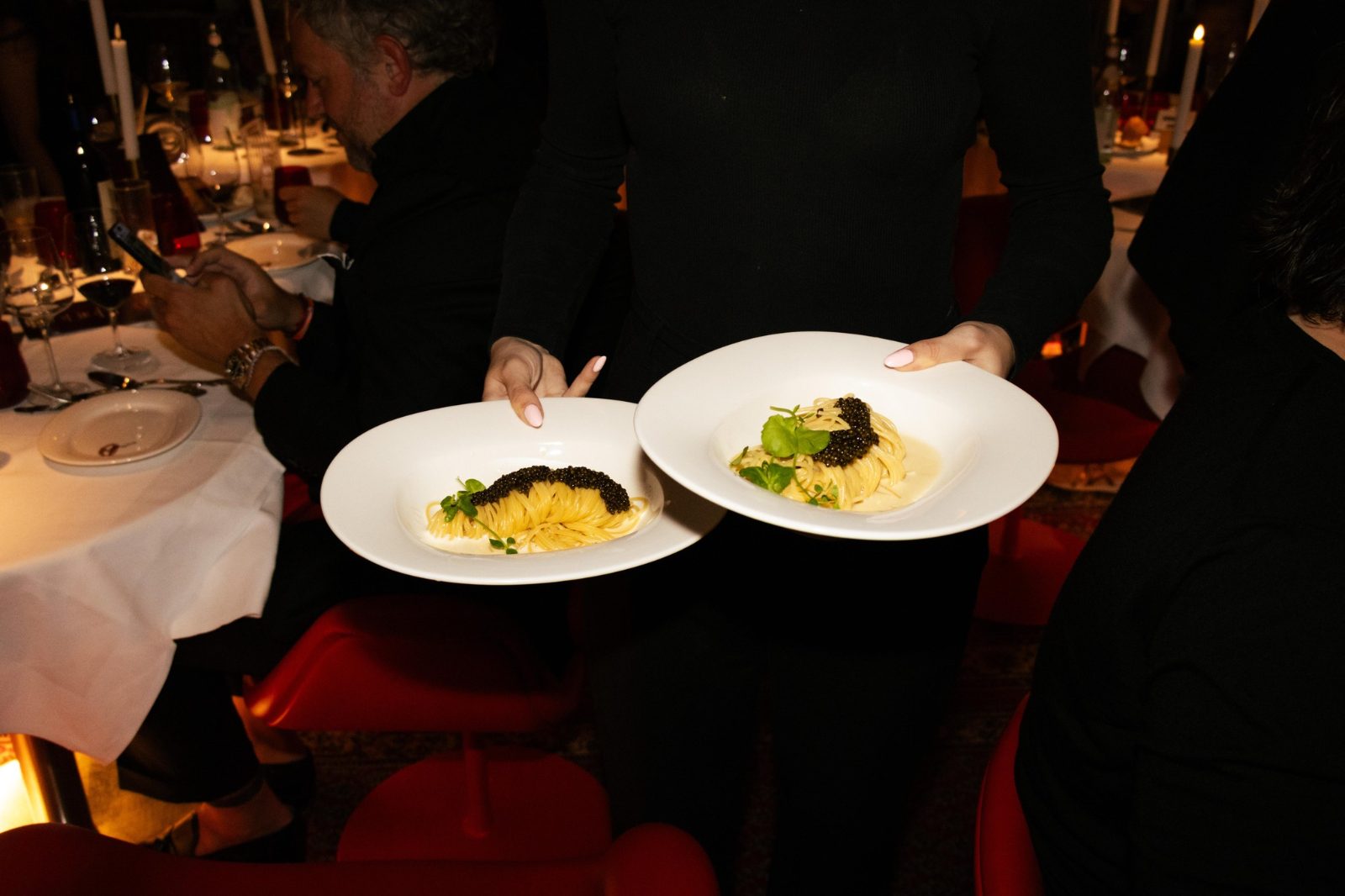 A server bringing two plates to the table at BISOUS on Albert Cuypstraat in Amsterdam