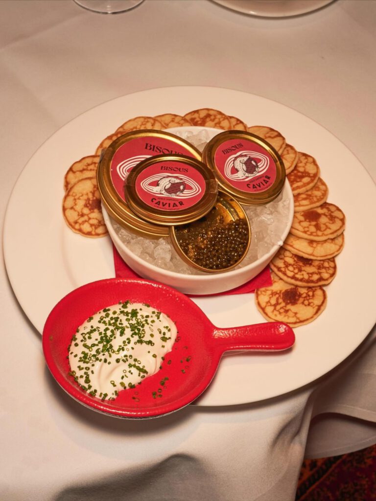 Tins of BISOUS Perle Imperial caviar on ice, with blinis and chive crème fraîche at BISOUS in Amsterdam
