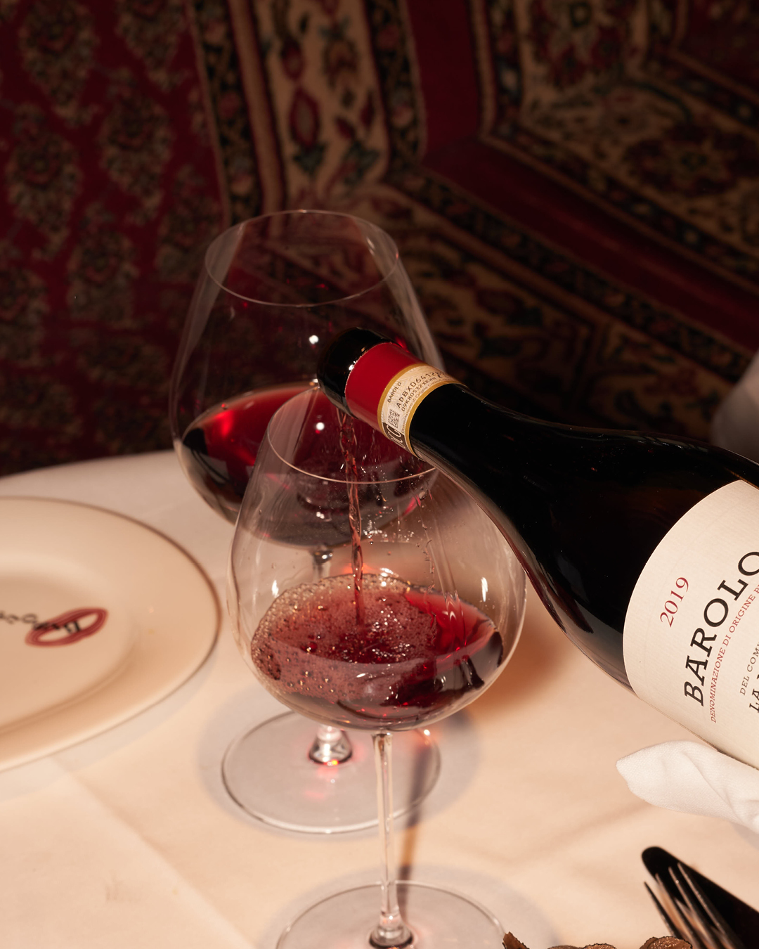 Red wine being poured at a dinner table at BISOUS in De Pijp